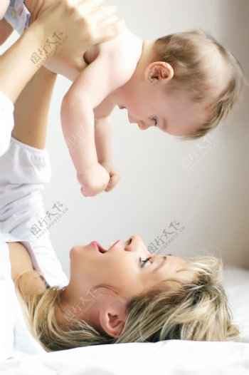 躺着的妈妈举起可爱的婴儿图片