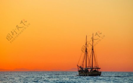 夕阳下大海上行驶的帆船