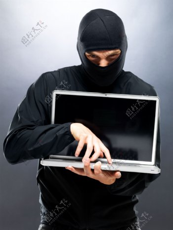 蒙面男人与笔记本电脑图片