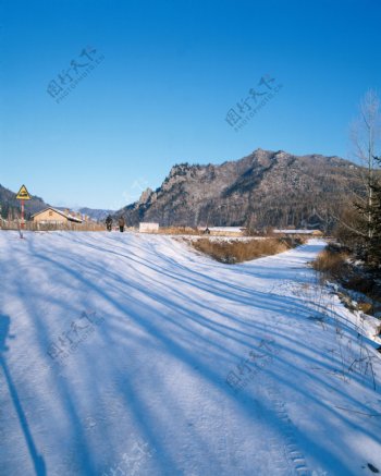 山林下的村庄行人雪景图片