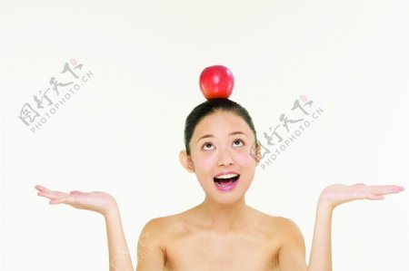 头顶苹果的健康美女图片