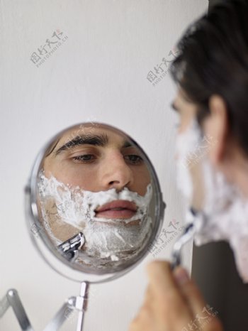 对着镜子刮胡子的男人图片