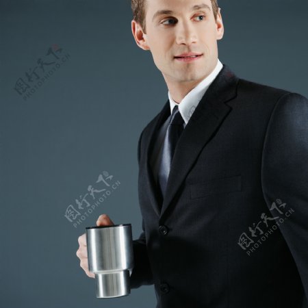 手端金属茶杯的商务人士图片