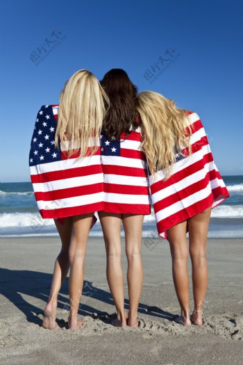 沙滩上披着国旗站着的外国美女背影