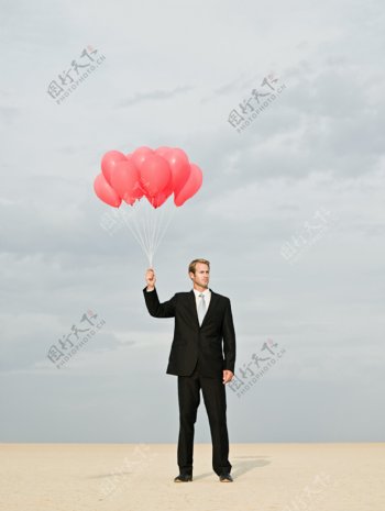 拿着气球的商务男士图片