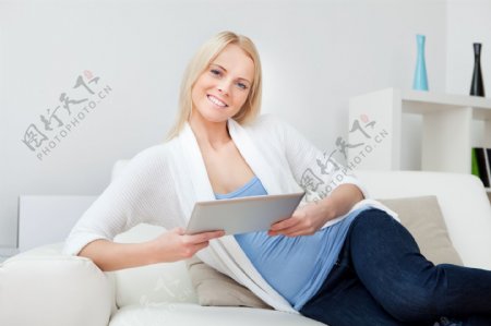 沙发上的美女和平板电脑图片