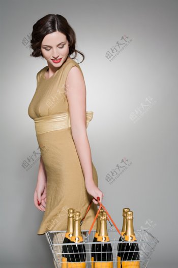 用购物篮提着六瓶香槟的女主妇图片
