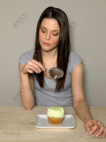 用放大镜观看蛋糕的外国美女图片