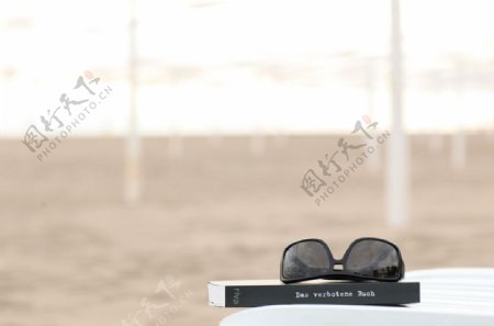 书和墨镜里面的沙滩图片