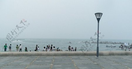 雨中海边游人图片