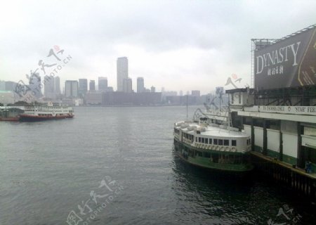 香港海边高楼维多里亚海港阴天云层船过渡图片
