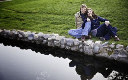 情侣在湖畔的草坪上偎依图片