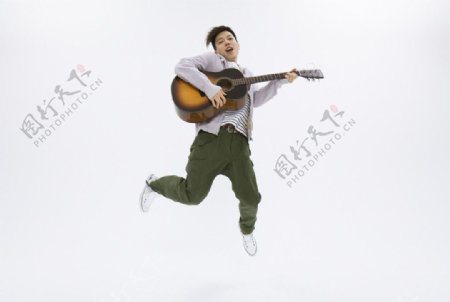 弹吉他跳跃的大学生图片