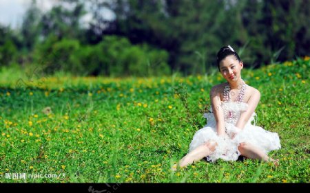 美女坐在草地上图片