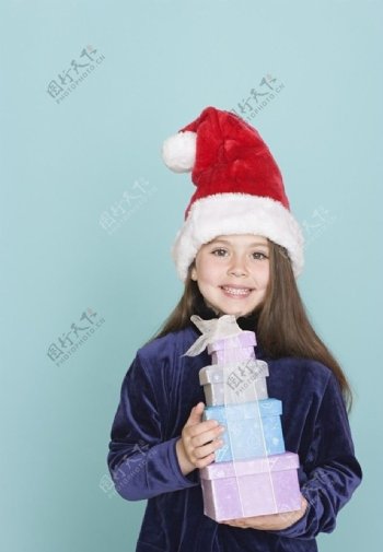 带圣诞帽捧着礼盒的甜蜜小女孩图片