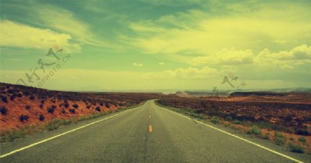 绿色天空下沙漠里的公路