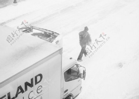 雪中路上的货车和行人
