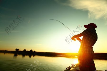 站在夕阳下钓鱼的男人
