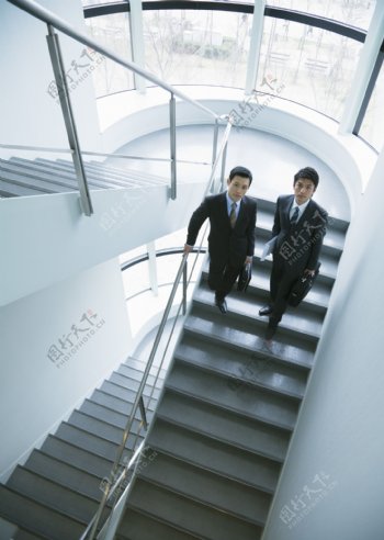 站在楼梯上的两个商务男人图片