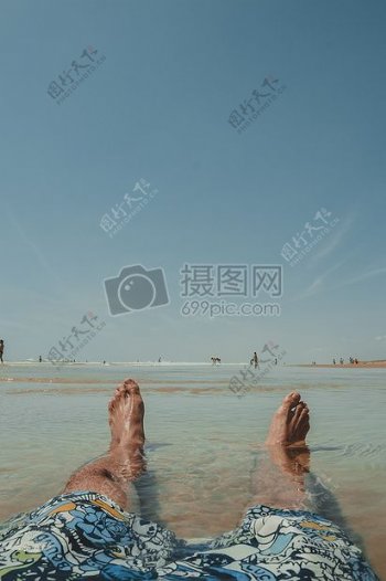人穿着乱画沙滩裤坐在表面水