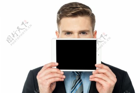 平板电脑挡着嘴的商务男士图片