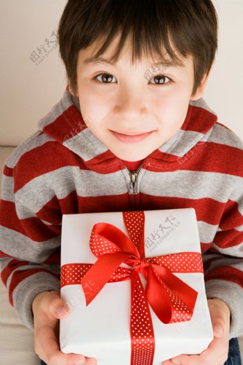 抱着礼物的可爱男孩图片