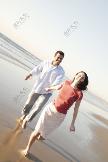 沙滩上手牵手的夫妻图片