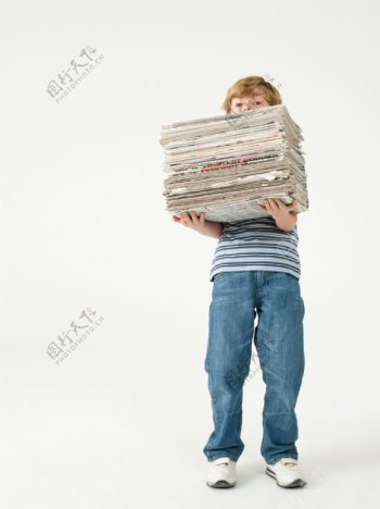 抱一摞报纸的男孩图片图片