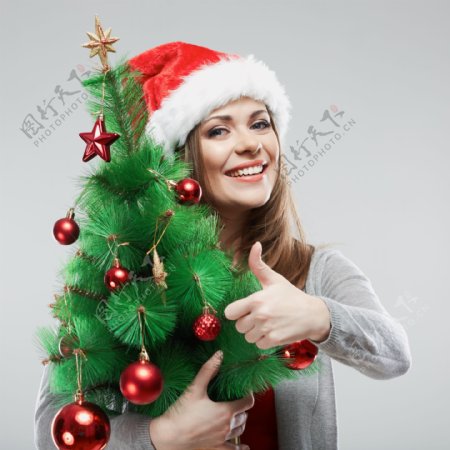 拿着圣诞树的美女图片
