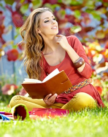 坐在草地上看书的美女图片