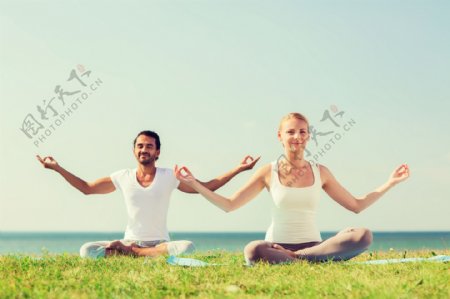 草地上做瑜珈的情侣图片