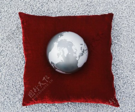 红色抱枕上的灰色地球摄影图片
