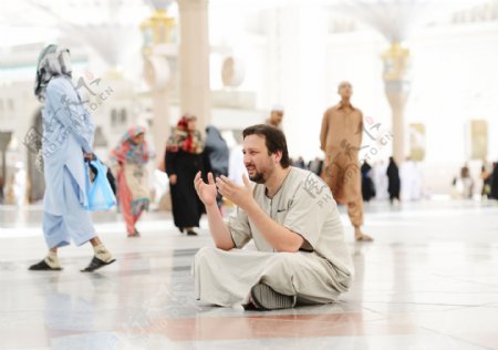 坐在地上祈祷的男人图片