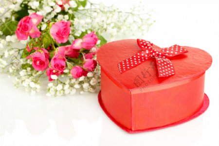 玫瑰花束边的心形礼物盒图片