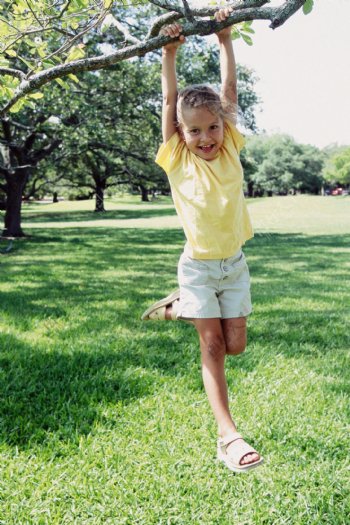 吊在树枝上玩耍的小女孩图片