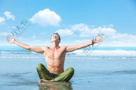 海滩练瑜伽的男士图片