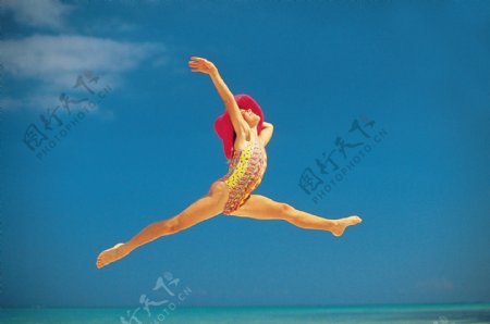 沙滩上跳跃的性感美女图片