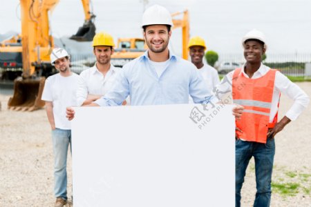 工程机械前抱着白板的工人图片