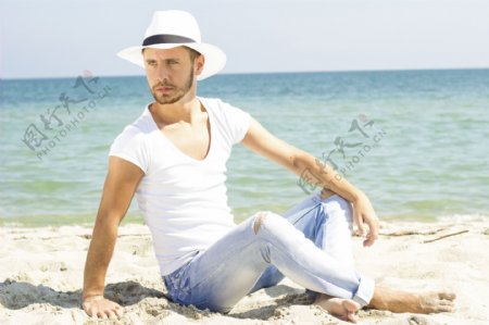 坐在沙滩上的牛仔裤模特图片