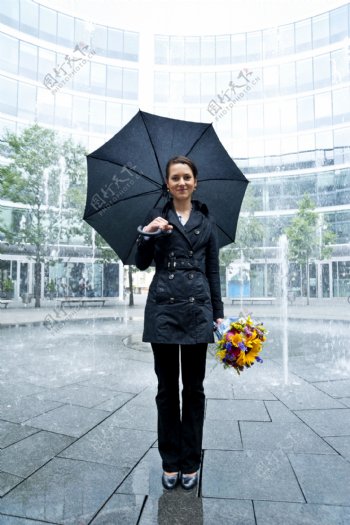 手拿鲜花打雨伞的时尚美女图片