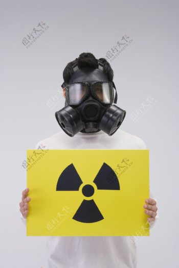 拿着核辐射符号板戴着面具的人图片图片