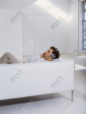躺在沙发上听音乐的男人图片