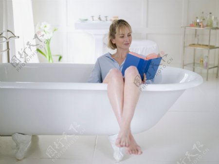 坐着浴缸里看书的女人图片