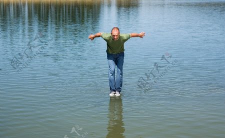 在水面上做跳跃动作的男人图片