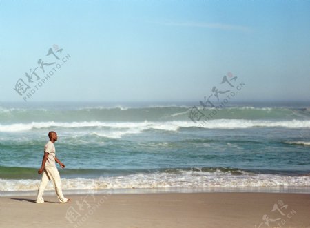 行走在沙滩上的男人图片
