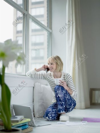电脑旁打电话拿着茶杯的女人图片