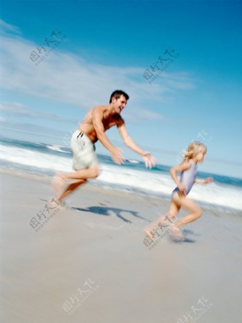 沙滩上追逐玩耍的父女图片