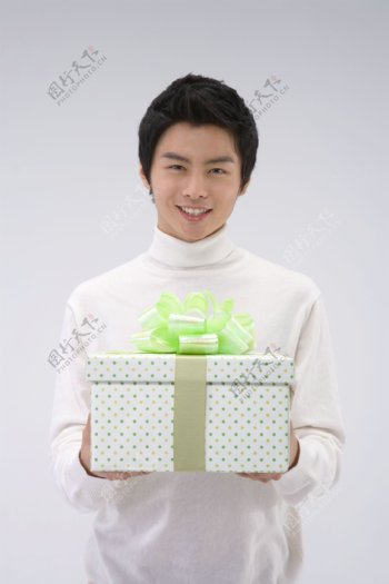 捧着礼品盒的快乐男孩图片图片