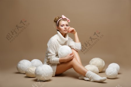 抱着棉线团坐着的美女图片
