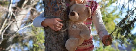 抱着玩具熊和树的女孩